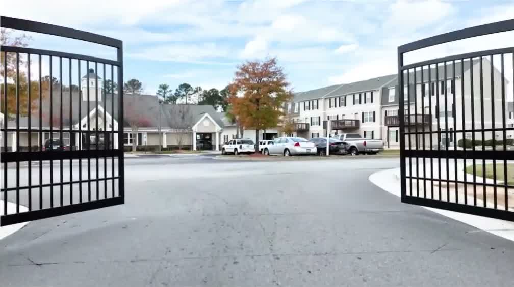 Example media: gates opening onto an apartment community
